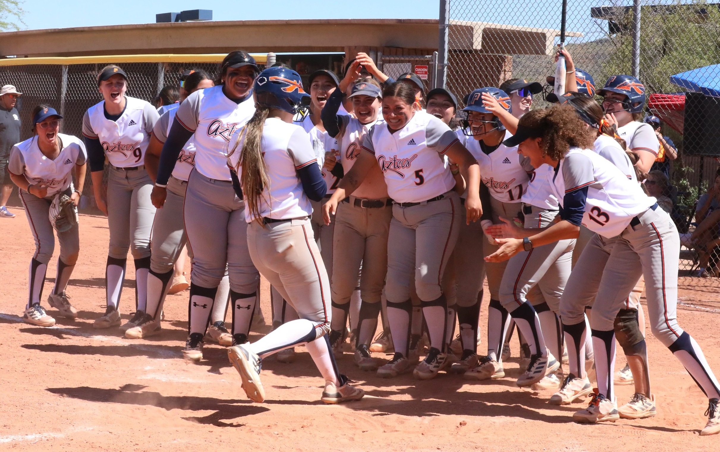 The Aztecs greet freshman Yanelyssia Chavez (Salpointe Catholic HS) as she crosses home plate after hitting the game-tying three-run home run in the 6th inning. Freshman Jazmyne Waddell (#5) hit a sacrifice-fly walk-off in the 7th as the Aztecs Softball team won their 26th straight game after sweeping Central Arizona College 13-12 and 10-5. The Aztecs are now 35-8 overall and 22-2 in ACCAC conference play. Photo by Steve Escobar